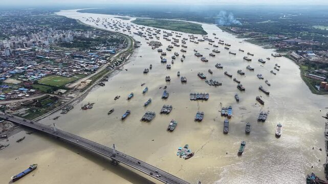 A high-altitude drone shot displays the vast scale of maritime congestion as cargo vessels shelter upstream on the Karnaphuli River in Chattogram, Bangladesh. 
