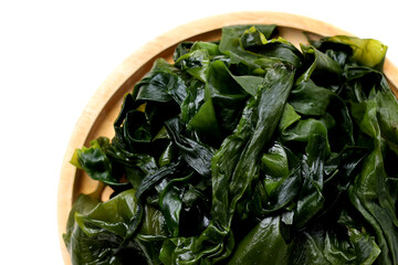Fresh green wakame seaweed on a white background.