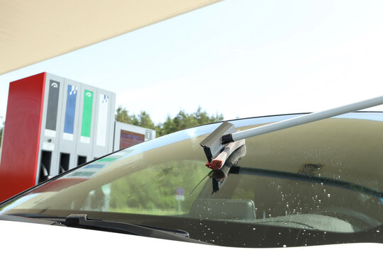 Windshield cleaning during refueling at a fuel station