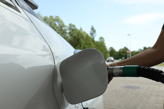 Car is being refueled at a gas station in the afternoon