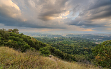 Obraz premium Layers of green mountains and hills in the haze during sunset. Panoramic View of Green hills and Meadow.