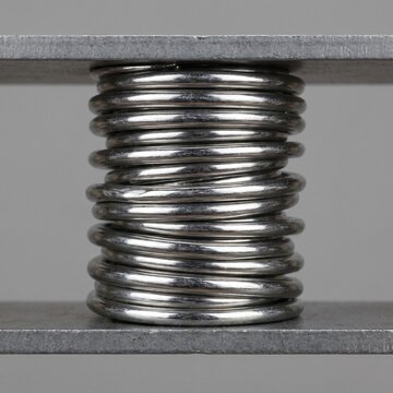 Compressed Steel Coil Spring as Resilience and Stored Energy Metaphor