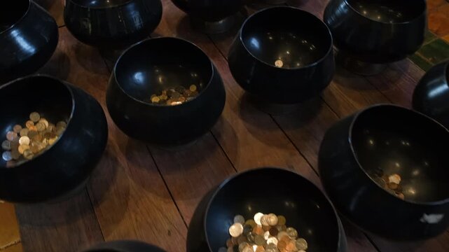 Rows of traditional Buddhist monk alms bowls arranged and displayed inside the temple hall