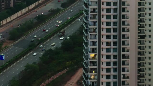 Reveal shot of outer ring road with service road, traffic flow, cycle track and tower building at kokapet, narsingi, nanakramguda, hyderabad, telangana, india. day time, trucking shot, drone shot, 4k.