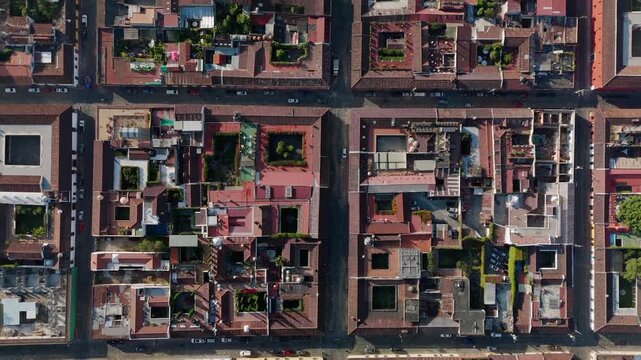 Aerial top view of grid layout in colonial city streets with historic architecture and red tile rooftops in Antigua Guatemala.