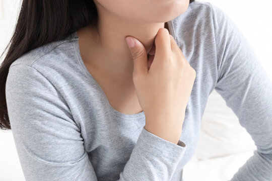 A young Chinese woman with a sore throat in the bedroom
