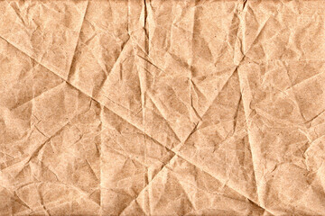 Fototapeta premium Crumpled brown paper texture. Wrinkled craft paper background with folded creases.