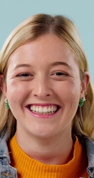 Happy, omg and face of woman in studio with good news, announcement or deal for prize. Excited, giveaway and portrait of person with celebration, wow or winning competition by blue background.