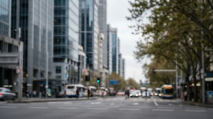 Obraz premium Blurred city street with modern skyscrapers and traffic, out of focus urban background, busy downtown road with buses and trees