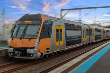 Obraz premium Passenger Train going through Lewisham Train Station at Sunset a suburban Sydney train Station in Sydney NSW Australia
