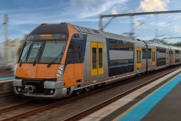 Obraz premium Passenger Train going through Lewisham Train Station at Sunset a suburban Sydney train Station in Sydney NSW Australia