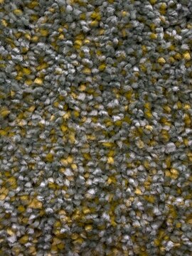Carpet texture background showing soft gray, yellow, and white fibers, creating a cozy and comfortable surface for interior design and flooring patterns