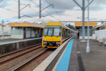 Fototapeta premium Passenger Train going through Lewisham Train Station at Sunset a suburban Sydney train Station in Sydney NSW Australia
