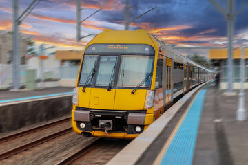 Obraz premium Passenger Train going through Lewisham Train Station at Sunset a suburban Sydney train Station in Sydney NSW Australia
