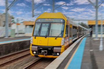Fototapeta premium Passenger Train going through Lewisham Train Station at Sunset a suburban Sydney train Station in Sydney NSW Australia
