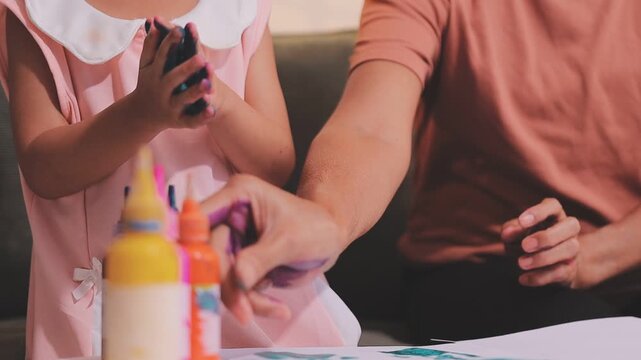 Small children hands hold wax crayons to draw rainbow on paper sheet. Diverse kids engage in creative craft activity together sitting on floor. Little students practice coloring skills at home school