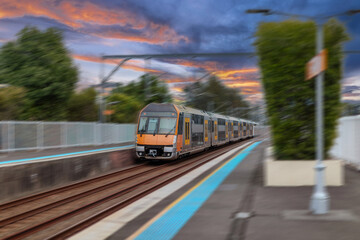 Obraz premium Passenger Train going through Lewisham Train Station at Sunset a suburban Sydney train Station in Sydney NSW Australia