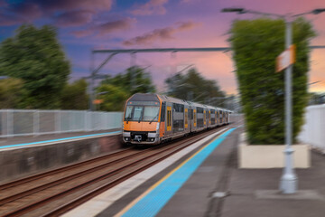 Obraz premium Passenger Train going through Lewisham Train Station at Sunset a suburban Sydney train Station in Sydney NSW Australia
