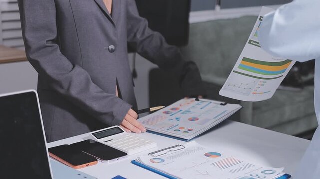 Accountant woman working on financial investment on calculator, calculation, business growth analysis and marketing on graph at office.
