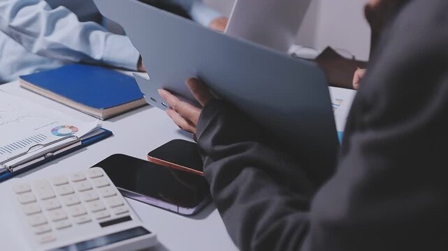 Accountant woman working on financial investment on calculator, calculation, business growth analysis and marketing on graph at office.