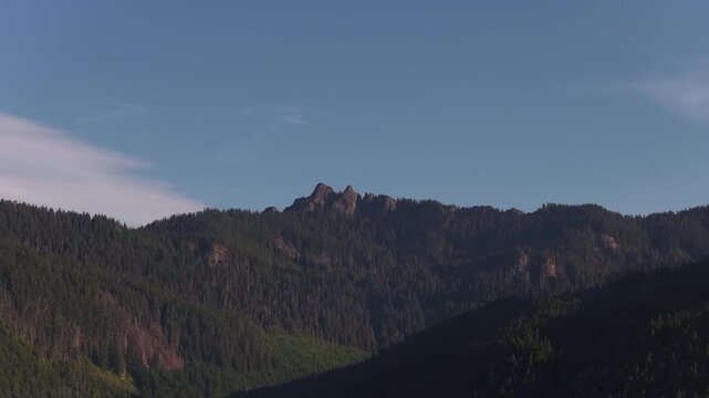 Aerial of Cascade mountain range in Mount Rainier National Park in Washington heavily forested with rocky jagged peaks in summer
