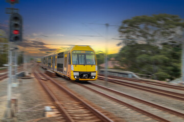 Obraz premium Passenger Train going through Lewisham Train Station at Sunset a suburban Sydney train Station in Sydney NSW Australia