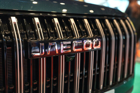 Penang, Malaysia - May 02, 2026: Close-up shot of the massive chrome vertical-slat grille and Jaecoo lettering emblem on a metallic grey J7 PHEV plug-in hybrid SUV displayed at a motor show.