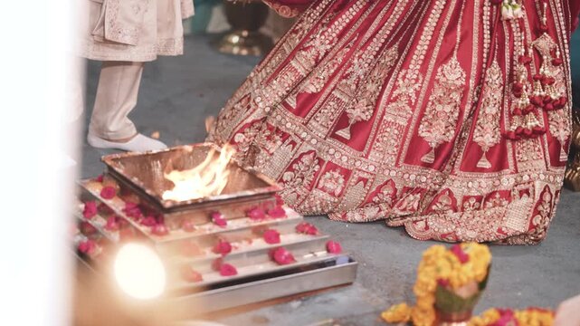 Indian bride and groom taking pheras or seven vows around the sacred havan fire during traditional hindu wedding ceremony