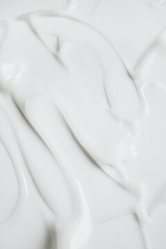 Smooth white cosmetic cream or lotion creating an abstract textured background