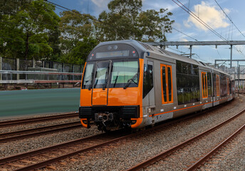Fototapeta premium Passenger Train going through Lewisham Train Station at Sunset a suburban Sydney train Station in Sydney NSW Australia
