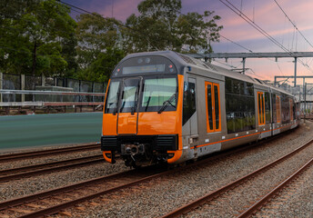 Fototapeta premium Passenger Train going through Lewisham Train Station at Sunset a suburban Sydney train Station in Sydney NSW Australia