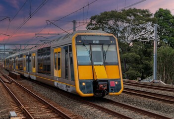 Obraz premium Passenger Train going through Lewisham Train Station at Sunset a suburban Sydney train Station in Sydney NSW Australia