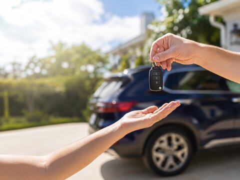 Entregar las llaves de un coche al nuevo propietario en un d&iacute;a soleado