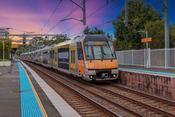 Obraz premium Passenger Train going through Lewisham Train Station at Sunset a suburban Sydney train Station in Sydney NSW Australia