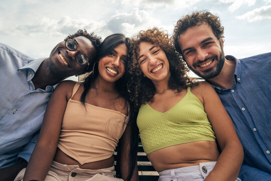 Close portrait of multicultural group of young friends smiling together outdoors