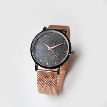 Elegant Rose Gold Analog Watch with Mesh Band and Black Textured Face on White Background