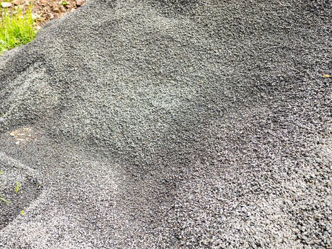 Crushed stone aggregate piled at a construction site. Gray gravel material used for roads, concrete, drainage and infrastructure projects with detailed natural texture.