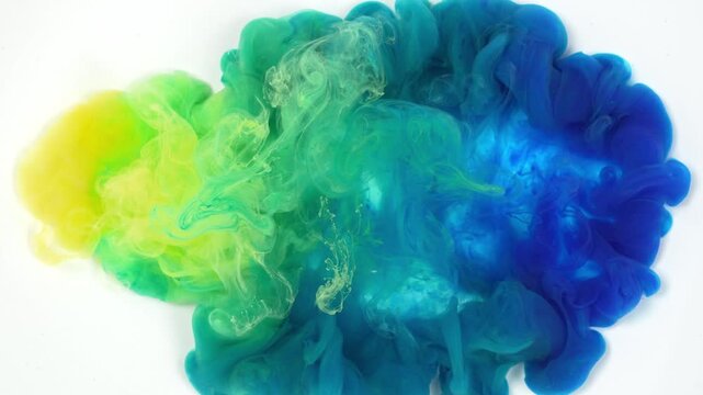 Abstract ink diffusion art with gradient yellow, green and blue pigment in clear water