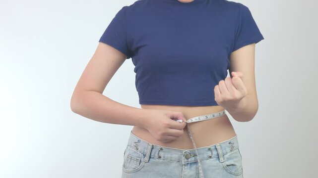 Determined proud woman holding tape to measure slim waist starting successful healthy weight loss fitness journey for fit body wellness