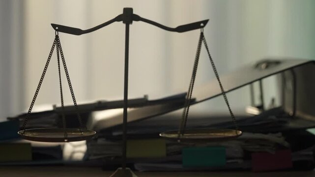 Scales of Justice Standing Before Stacks of Legal Documents Awaiting Case Review