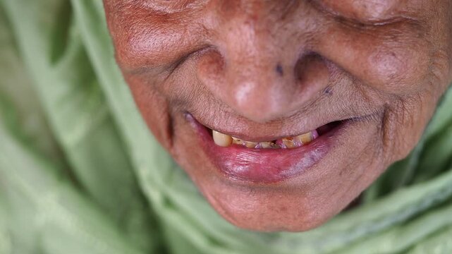 Elderly woman smiles while wearing a green shawl