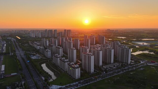 Aerial dusk view of dense high-rise residential buildings under golden sunset sky