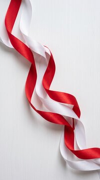 Red and white twisted gift ribbon isolated on white. Elegant satin decorative bow for packaging and crafts