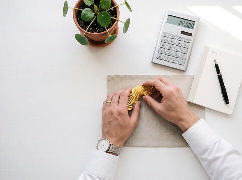 Overhead minimalist financial workspace flat lay with calculator and polished coins on white background