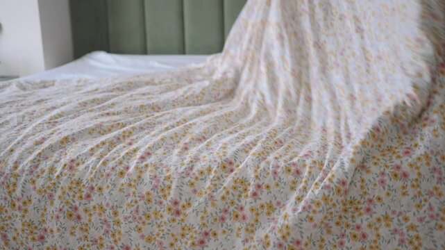 Making a bed with a fresh sheet in a bedroom