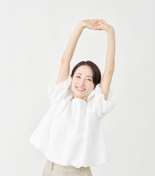 伸びをするミドルエイジ女性　白背景