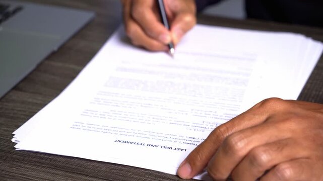 Person Writing on Last Will and Testament Document