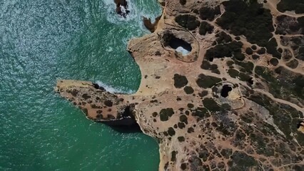 Aerial view of rocky coast with cliffs and green vegetation © Iustin