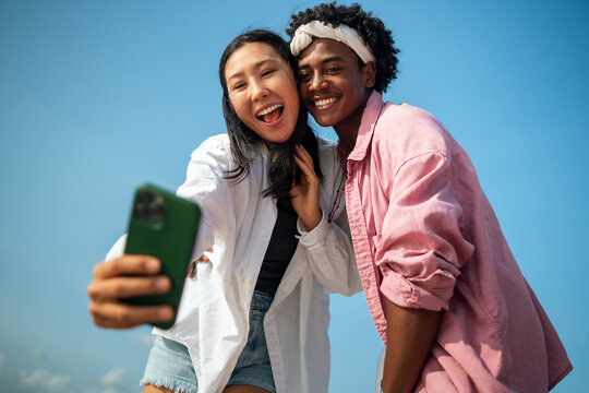 Happy moments by the beach, friends enjoying mobile connection, social media, and summer vibes
