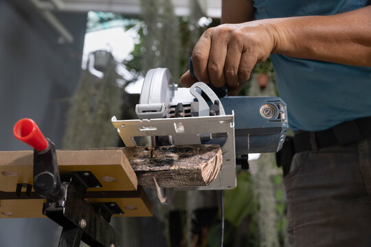 Circular saw straight crosscut wood on sawhorses. Low angle view.